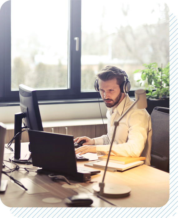 Man wearing a headset in front of a computer